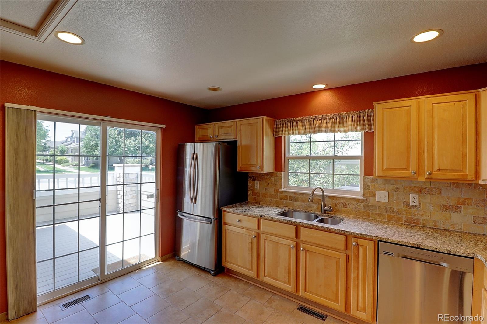 6203 Trailhead Road Highlands Ranch, CO 80130 - Photo 10 of 32 a kitchen that has a sink a refrigerator and cabinets