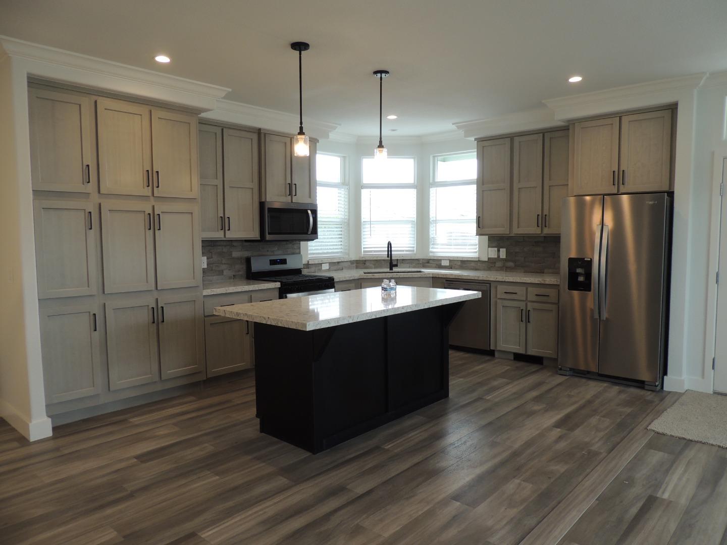 144 Holm Road, Unit 93 Watsonville, CA 95076 - Photo 4 of 15 a kitchen with stainless steel appliances granite countertop a sink a stove a refrigerator and island with wooden floor