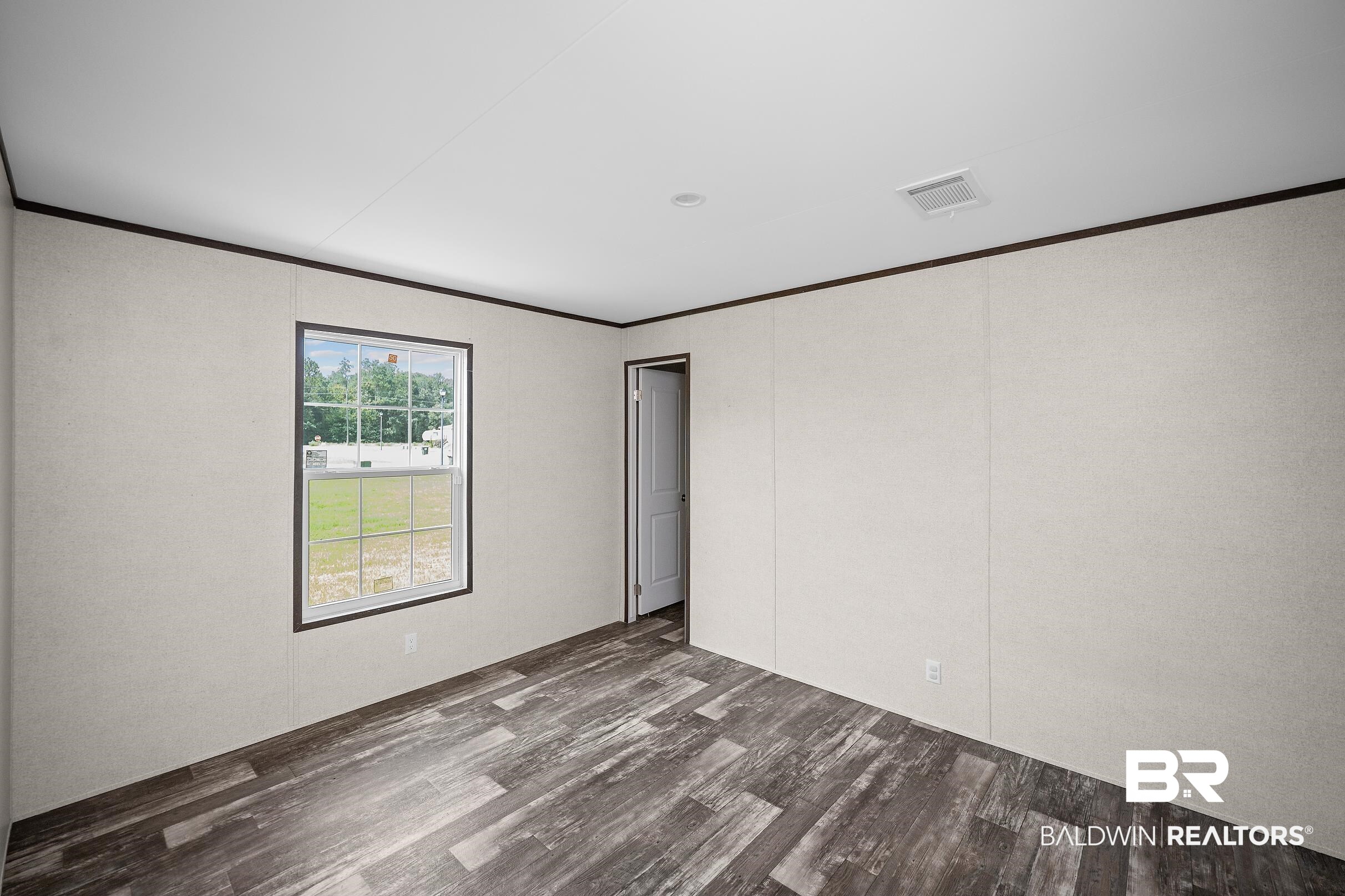 21601 Westside Loop Silverhill, AL 36576 - Photo 32 of 42 Room featuring wood-finish flooring, white panel walls, and dark trim accents