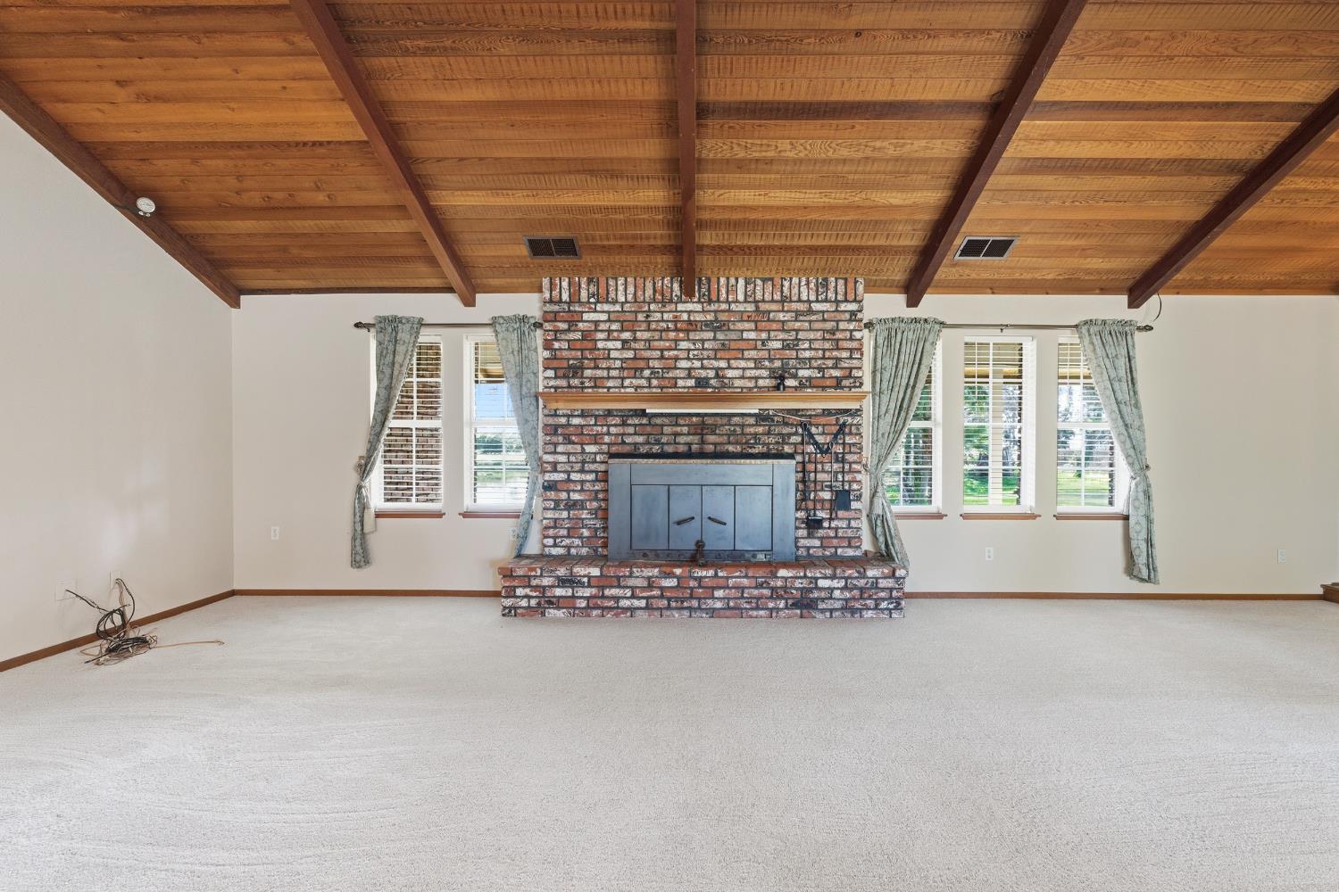 7176 East Butler Avenue Fresno, CA 93737 - Photo 14 of 76 a view of an empty room with a fireplace and a window