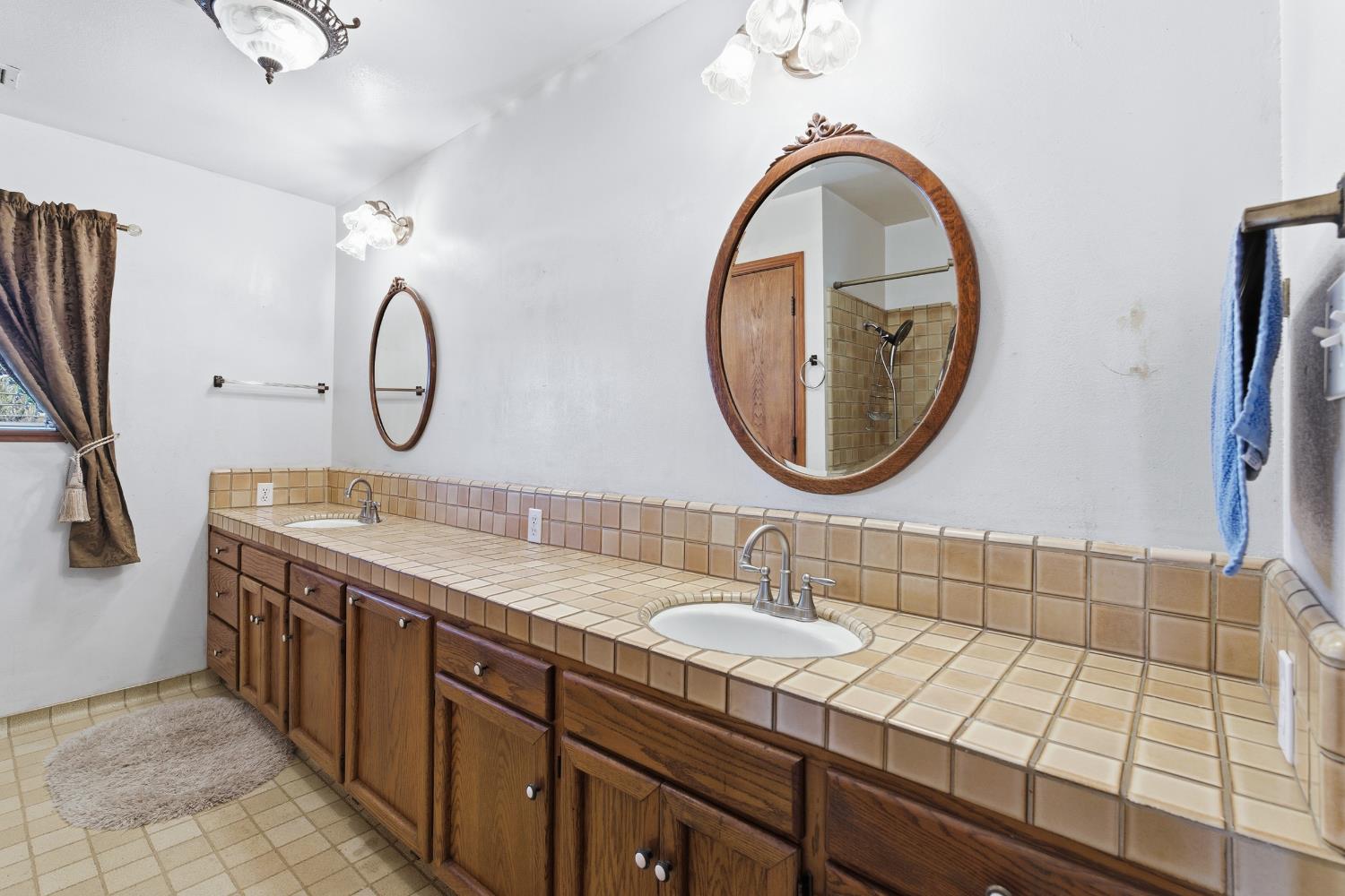 7176 East Butler Avenue Fresno, CA 93737 - Photo 30 of 76 a bathroom with a double vanity sink and a mirror