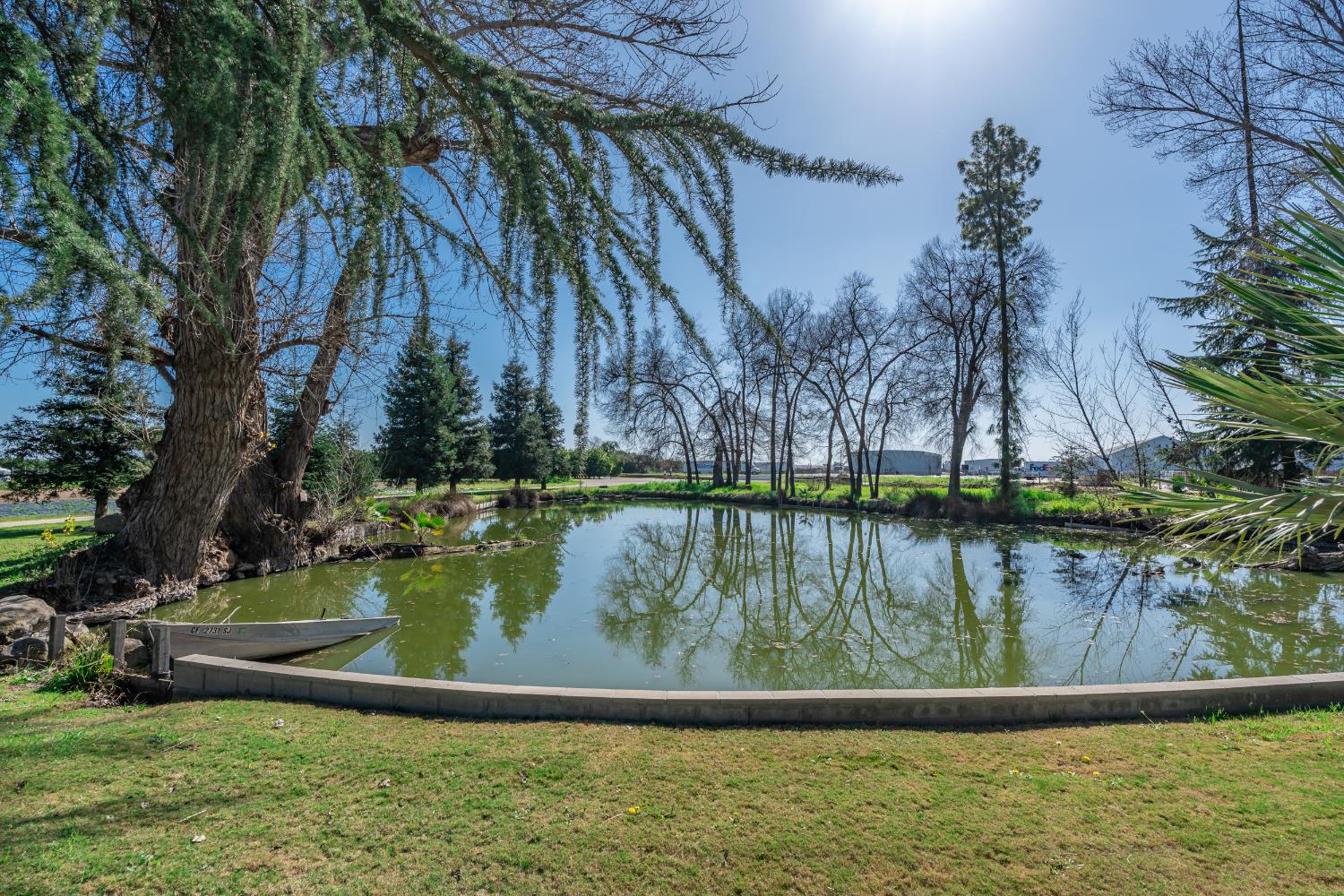 7176 East Butler Avenue Fresno, CA 93737 - Photo 43 of 76 a view of a lake with a house in the background