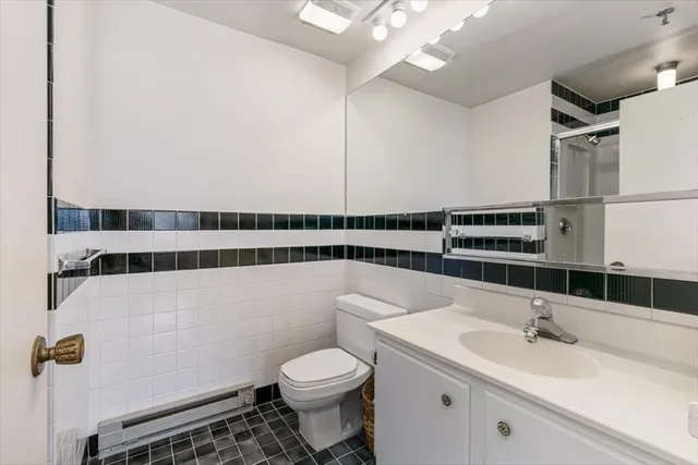 a bathroom with a sink toilet vanity and shower
