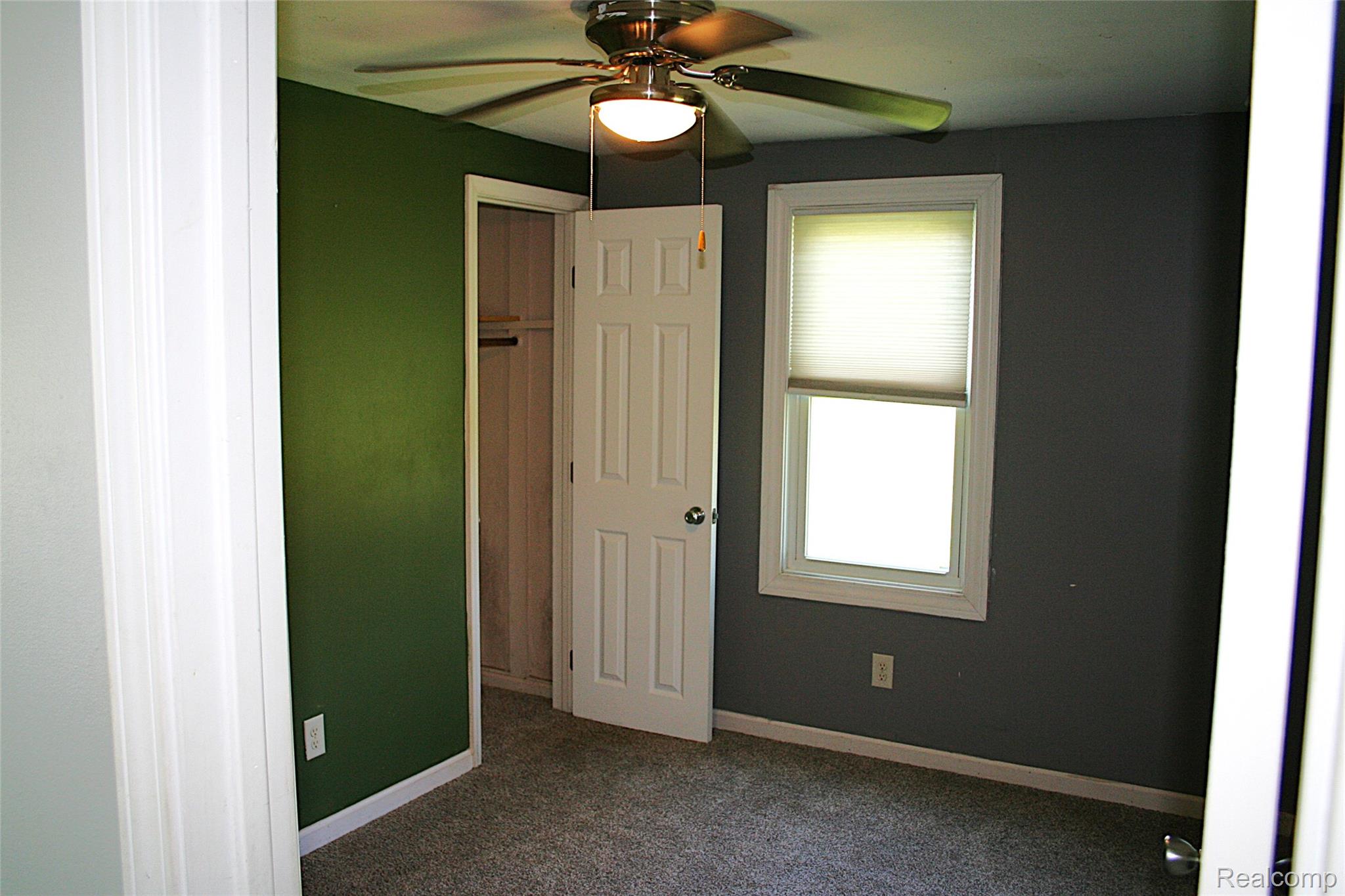 2199 Sandy Creek Road Monroe, MI 48162 - Photo 10 of 13 Unfurnished bedroom featuring dark carpet, multiple windows, and a ceiling fan