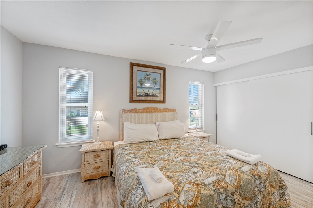 622 Beach Access Rd- 1a, Unit 231 Port Aransas, TX 78373 - Photo 12 of 24 a bedroom with a bed and wooden floor