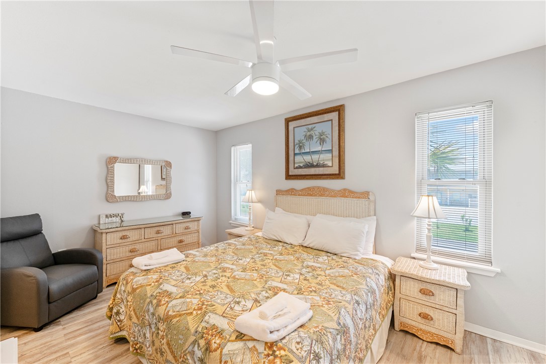 622 Beach Access Rd- 1a, Unit 231 Port Aransas, TX 78373 - Photo 14 of 24 a bedroom with a bed and wooden floor