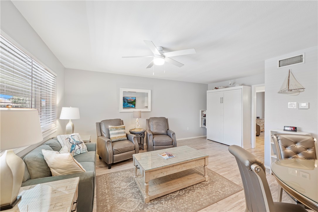 622 Beach Access Rd- 1a, Unit 231 Port Aransas, TX 78373 - Photo 15 of 24 a spacious bedroom with a bed a couch and a chandelier