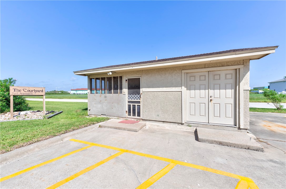 622 Beach Access Rd- 1a, Unit 231 Port Aransas, TX 78373 - Photo 18 of 24 a front view of a house with a yard and swimming pool