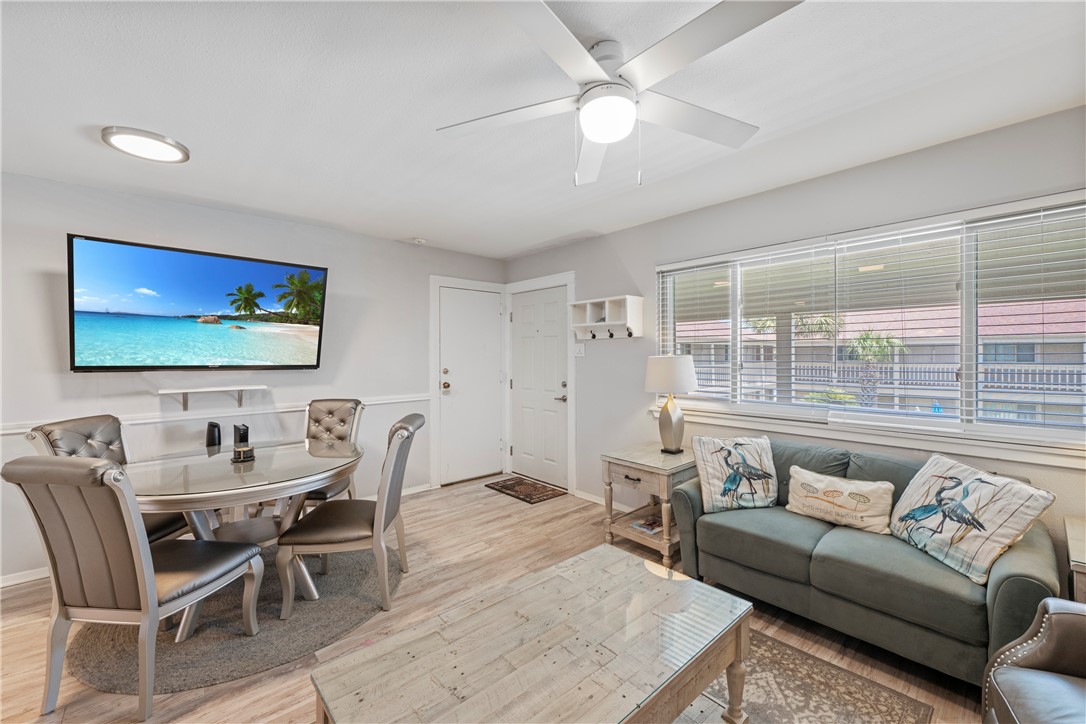 622 Beach Access Rd- 1a, Unit 231 Port Aransas, TX 78373 - Photo 4 of 24 a living room with furniture a large window and a flat screen tv