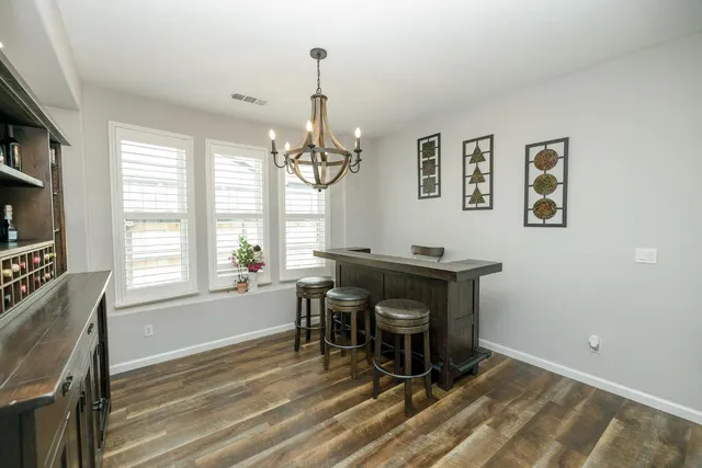 a large kitchen with kitchen island a sink stainless steel appliances and a chandelier