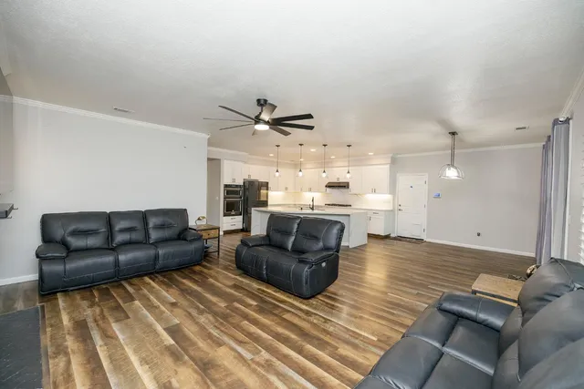 a view of an empty room with window and chandelier fan