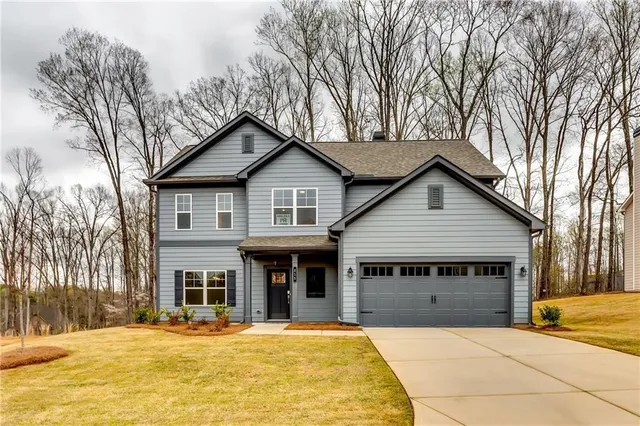 a view of house with outdoor space and trees in the background