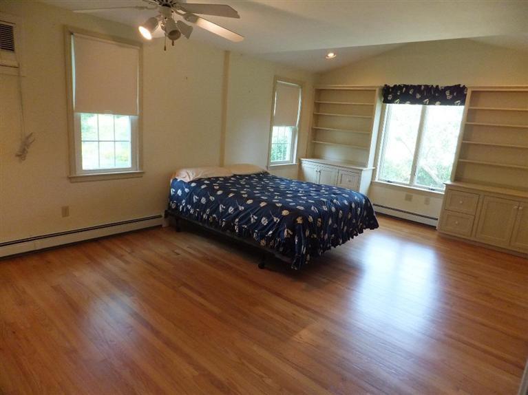 14 Brick Hill Road Orleans, MA 02653 - Photo 12 of 27 a bedroom with a bed window and wooden floor