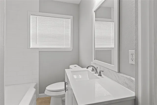 a white toilet sitting next to a bathroom sink