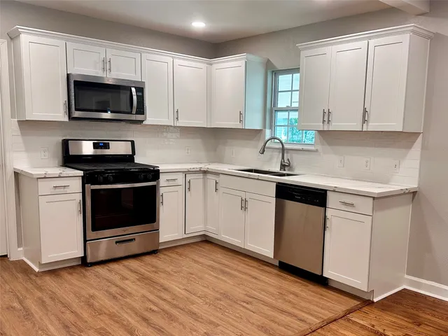 a kitchen with a sink stove and microwave