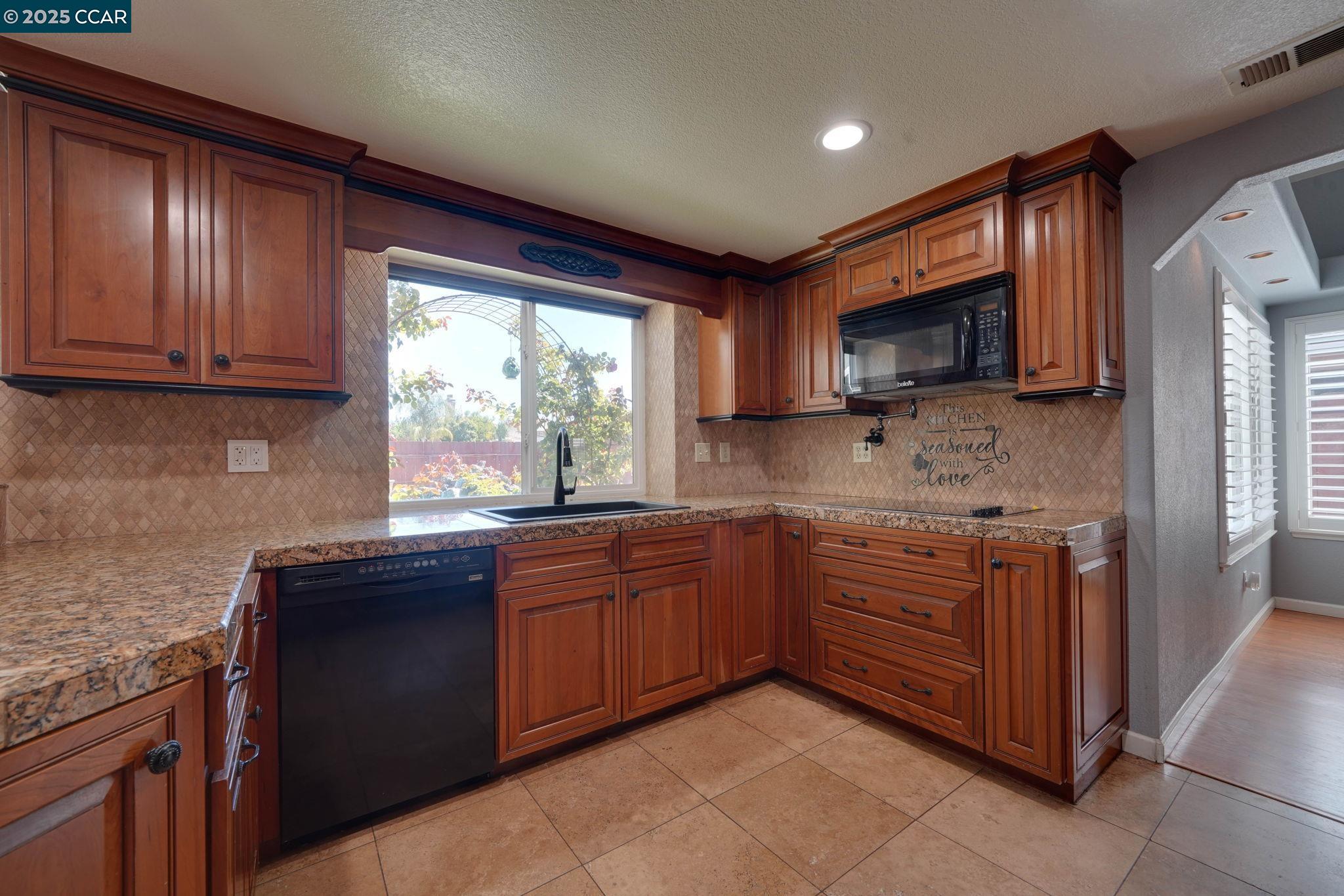 1210 Snow Ridge Court Modesto, CA 95351 - Photo 12 of 43 a kitchen with stainless steel appliances granite countertop wooden cabinets a sink and a stove