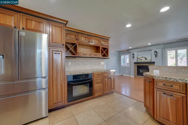 a kitchen with granite countertop a refrigerator and a stove top oven
