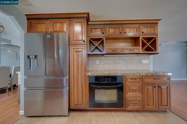 a kitchen with stainless steel appliances granite countertop a refrigerator and a stove