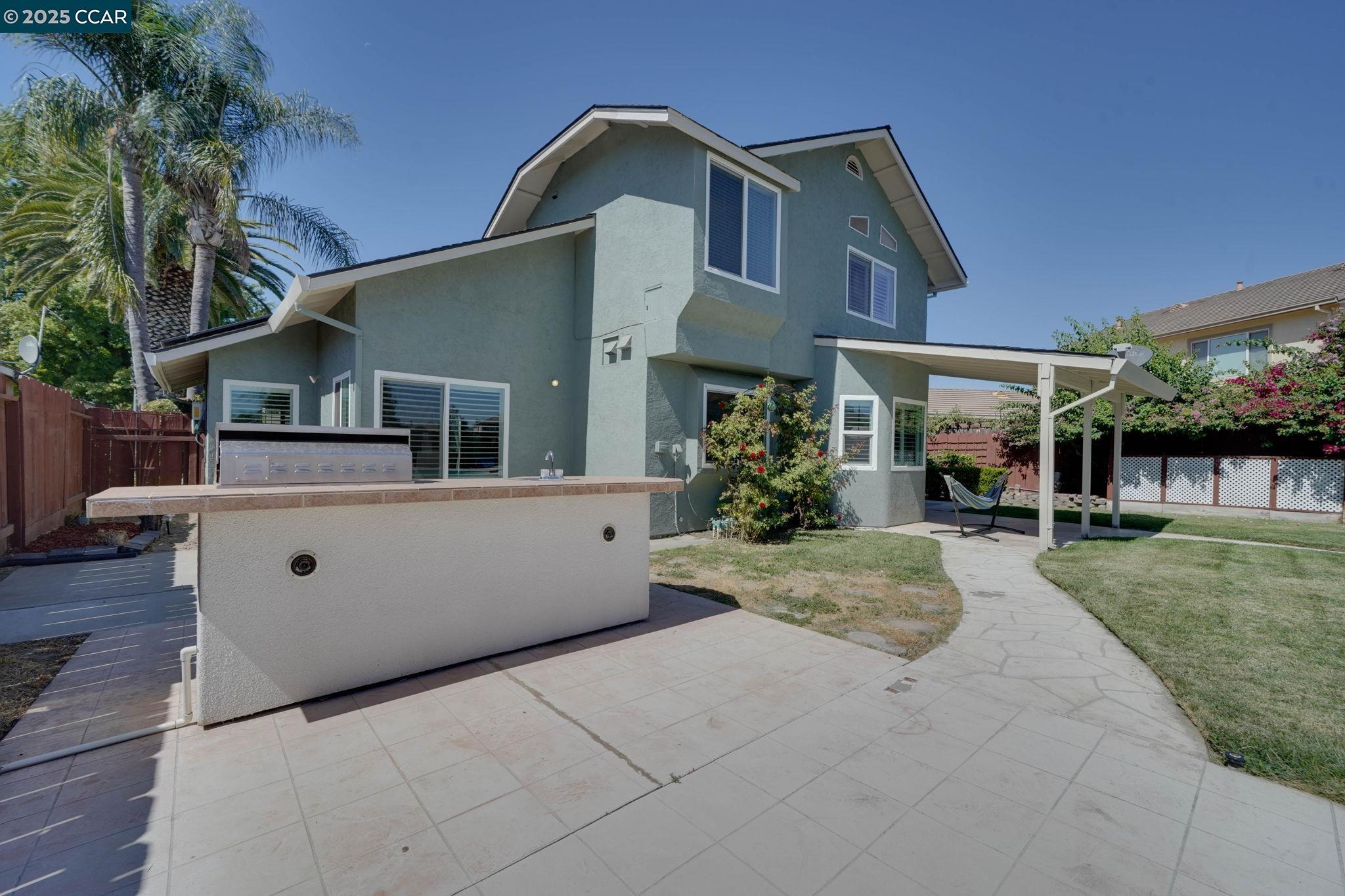 1210 Snow Ridge Court Modesto, CA 95351 - Photo 22 of 43 a view of a white house next to a yard with potted plants