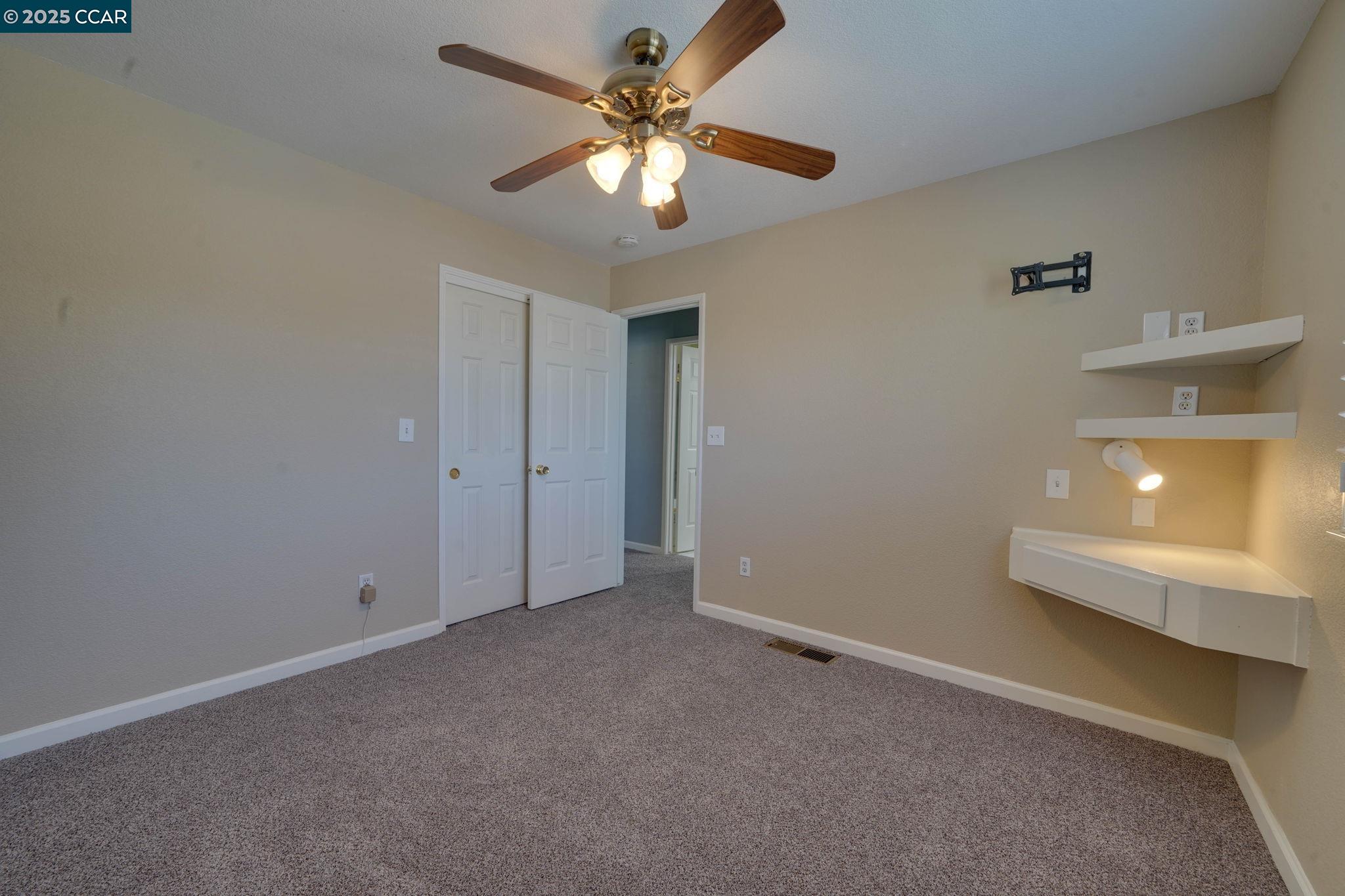 1210 Snow Ridge Court Modesto, CA 95351 - Photo 32 of 43 a view of an empty room with a chandelier fan