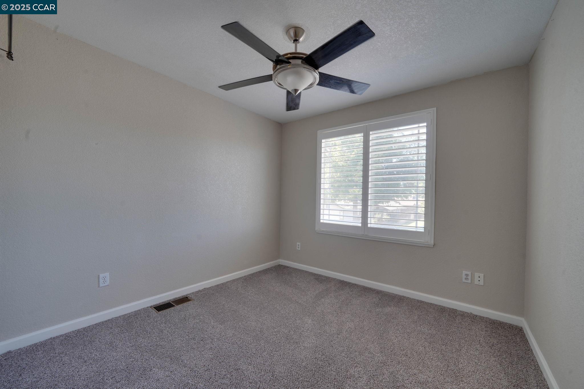 1210 Snow Ridge Court Modesto, CA 95351 - Photo 35 of 43 an empty room with ceiling fan and windows