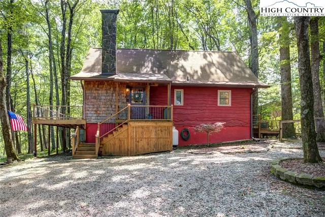 a living room with furniture a couch and potted plant with wooden floor