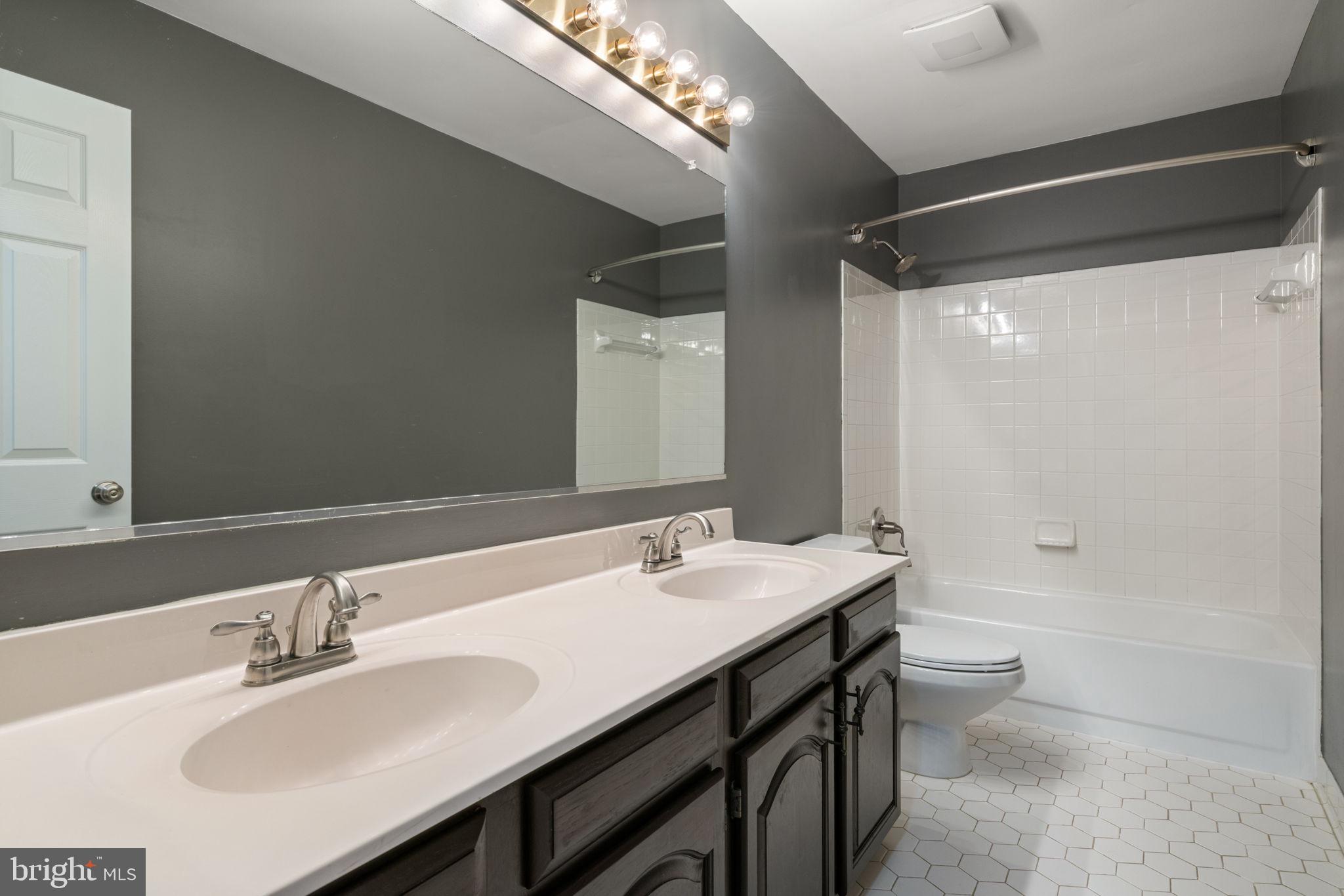 8527 Silverview Drive Lorton, VA 22079 - Photo 22 of 63 a bathroom with a double vanity sink and a mirror