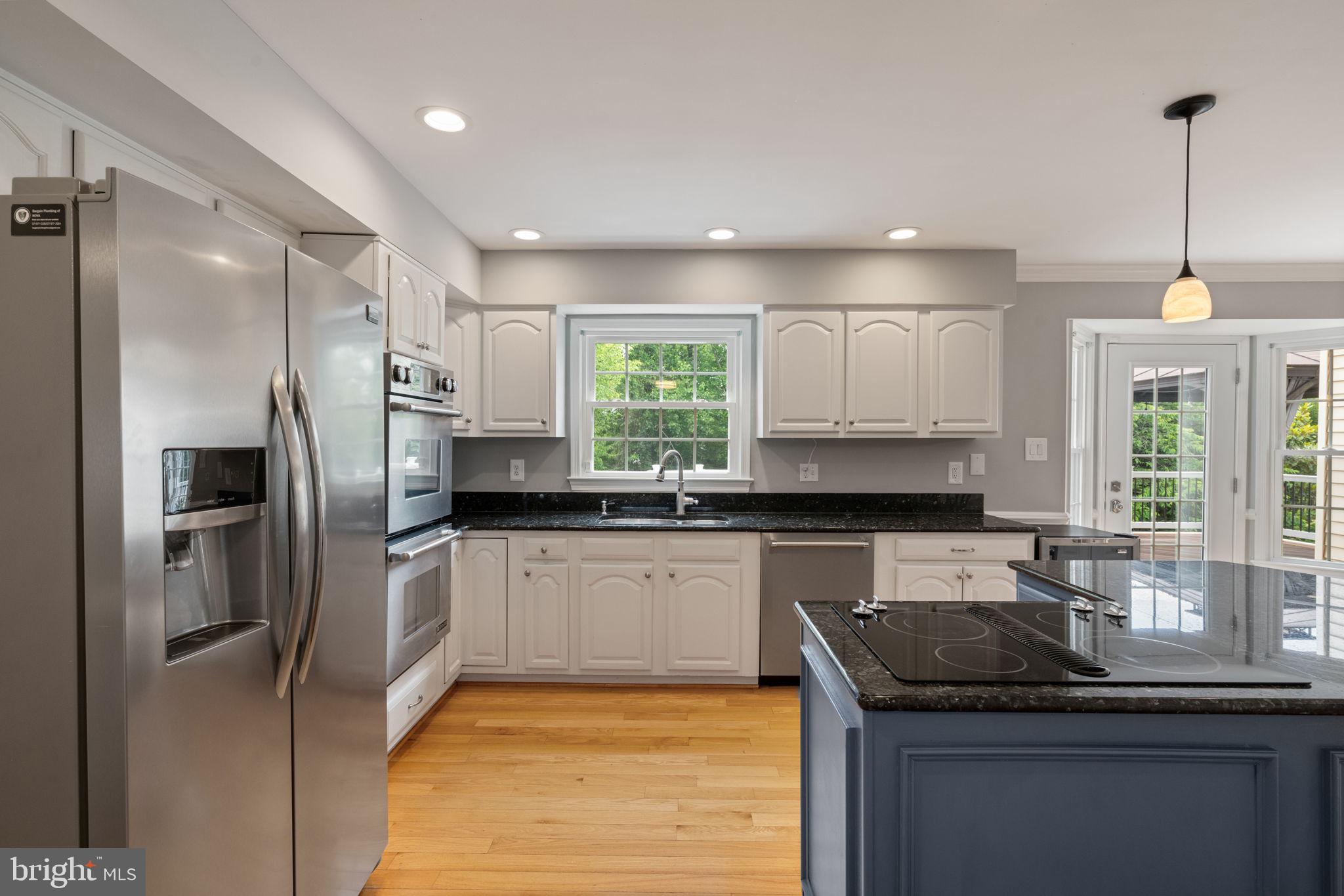 8527 Silverview Drive Lorton, VA 22079 - Photo 38 of 63 a kitchen with kitchen island granite countertop a sink stainless steel appliances and cabinets