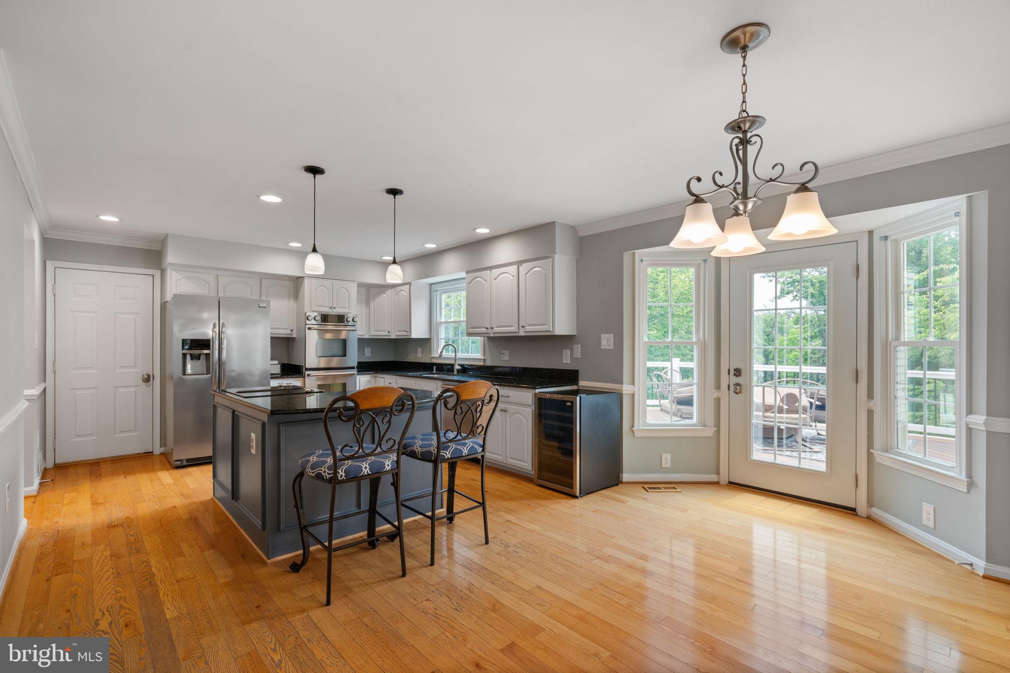 8527 Silverview Drive Lorton, VA 22079 - Photo 44 of 63 a kitchen with a table chairs refrigerator and microwave