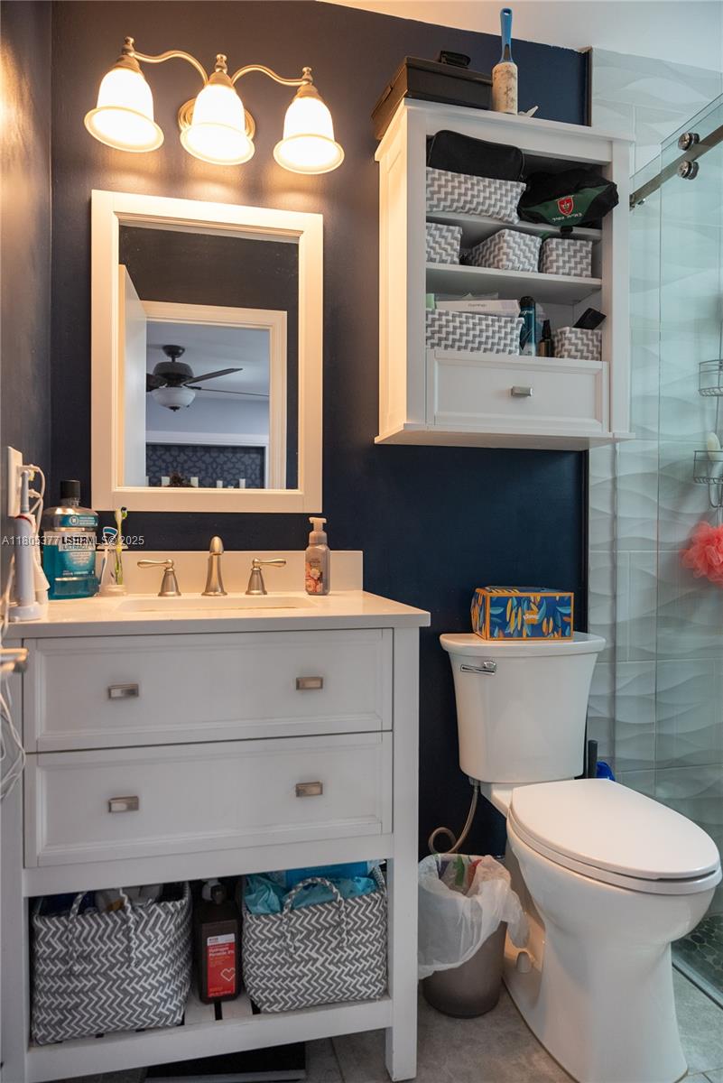 19663 Hampton Drive Boca Raton, FL 33434 - Photo 7 of 33 a bathroom with a sink a toilet and a mirror