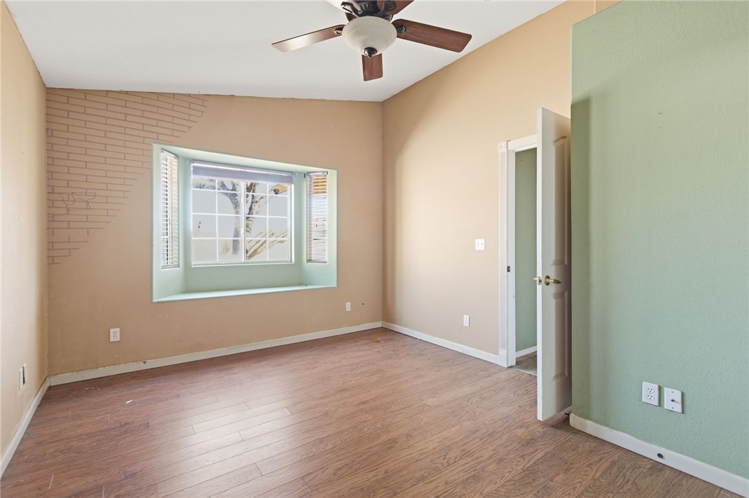 3740 North Kenneth Road Kingman, AZ 86409 - Photo 12 of 26 Empty room with vaulted ceiling, light wood-type flooring, and ceiling fan