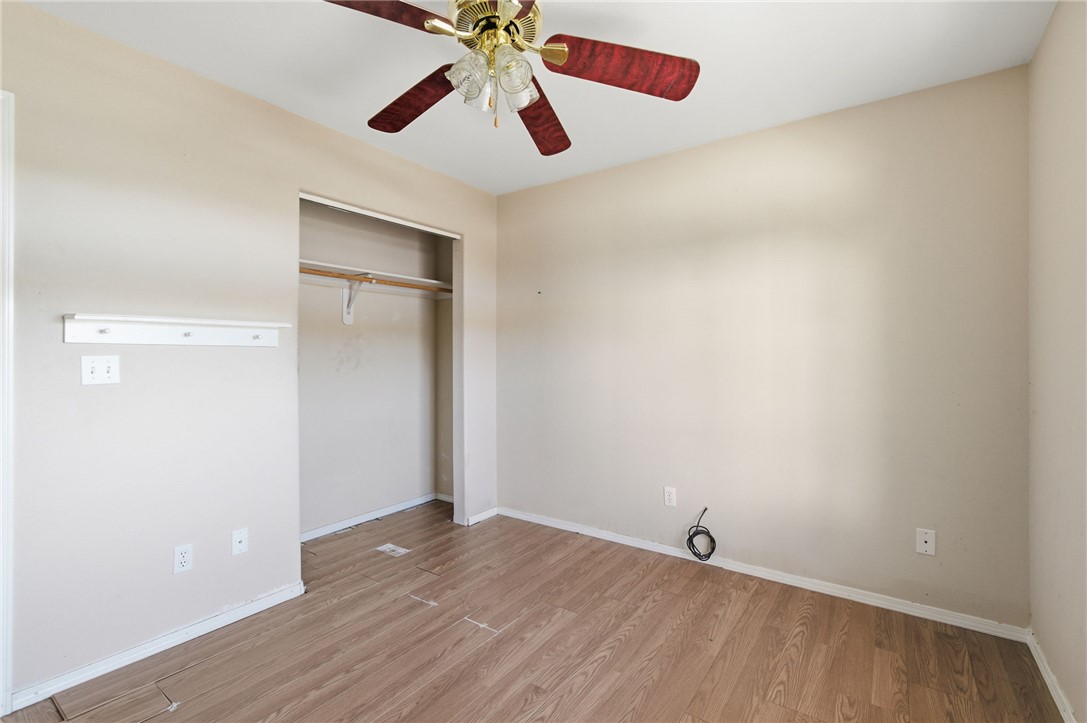 3740 North Kenneth Road Kingman, AZ 86409 - Photo 16 of 26 Unfurnished bedroom featuring light wood finished floors, a ceiling fan, and a closet
