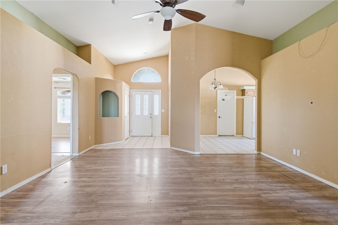 3740 North Kenneth Road Kingman, AZ 86409 - Photo 4 of 26 Entryway with arched walkways, a ceiling fan, light wood finished floors, and high vaulted ceiling