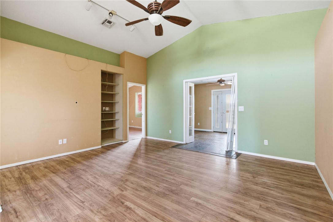 3740 North Kenneth Road Kingman, AZ 86409 - Photo 6 of 26 Spare room with a ceiling fan, light wood-style flooring, built in features, high vaulted ceiling, and track lighting
