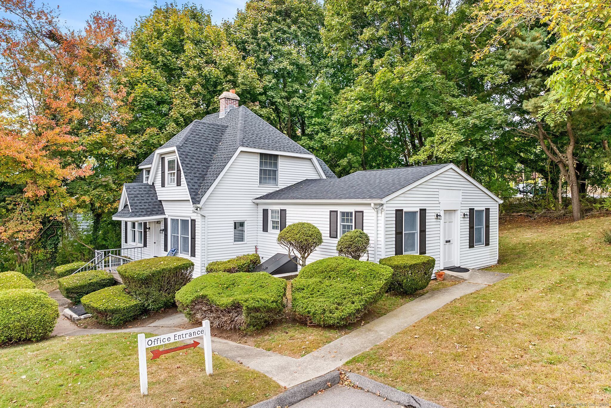 a front view of house with yard and trees in the background