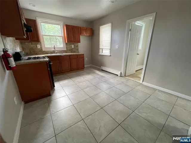 a kitchen with granite countertop a sink a stove a microwave and cabinets