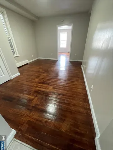 a view of an empty room and wooden floor