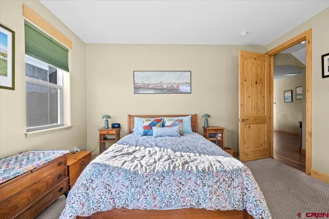 a bedroom with a large bed and wooden floor