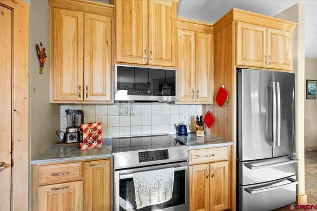 a kitchen with stainless steel appliances granite countertop a refrigerator and a stove top oven