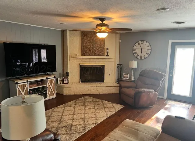 a living room with furniture a flat screen tv and kitchen view