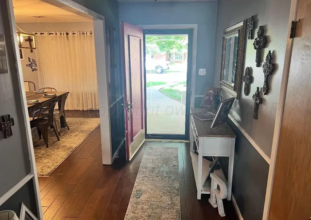 a view of a hallway with furniture and a window