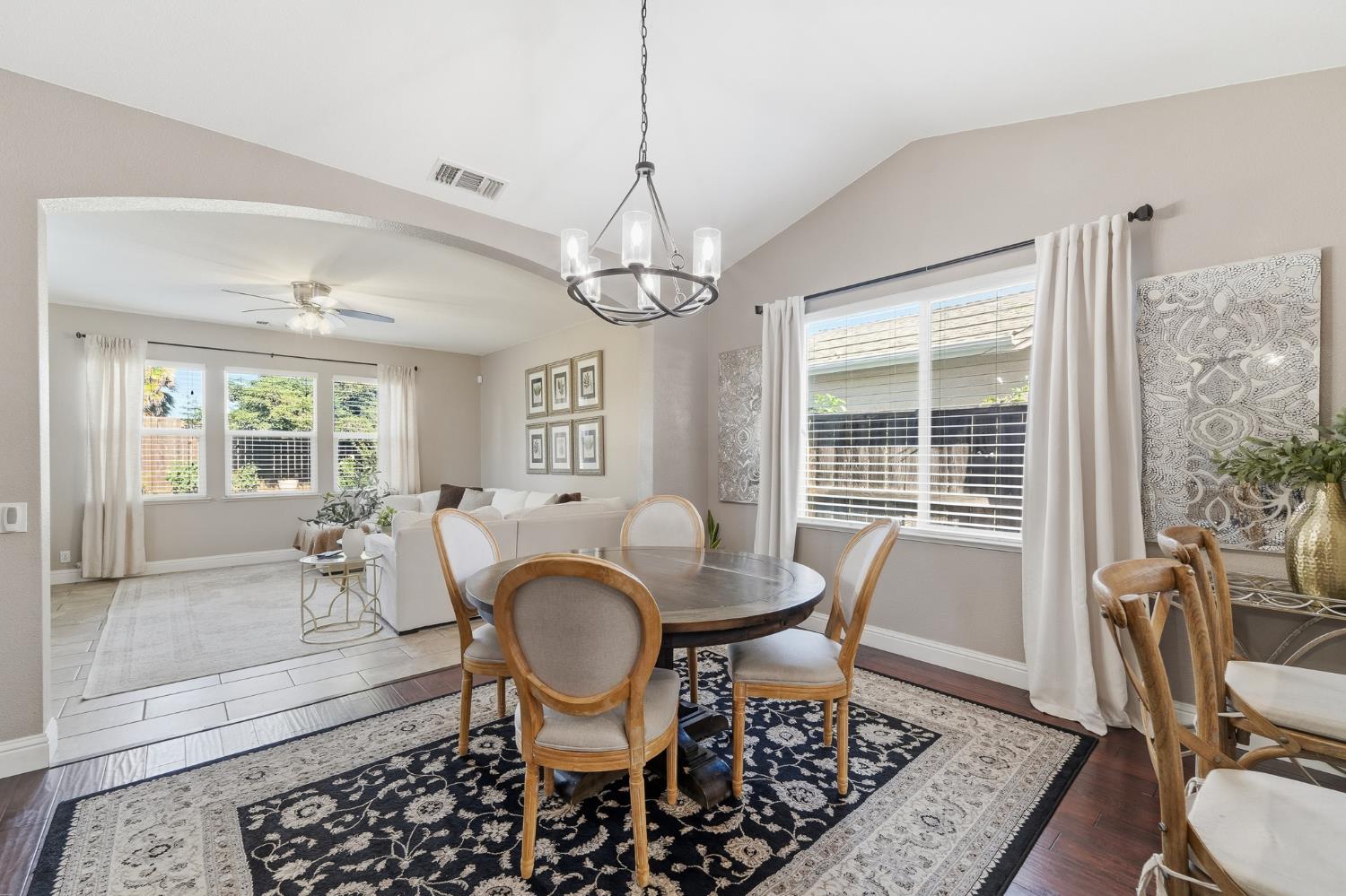 2220 Ellison Drive Modesto, CA 95355 - Photo 14 of 53 a dining room with wooden floor a chandelier a glass table and chairs
