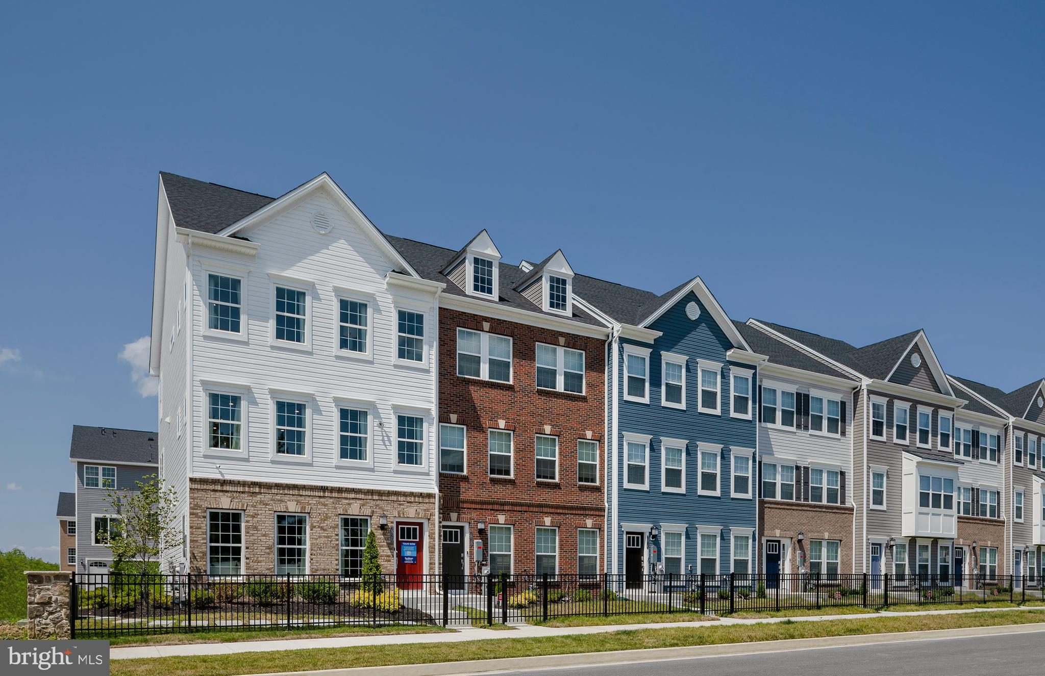 a front view of a building with lot of trees and plants