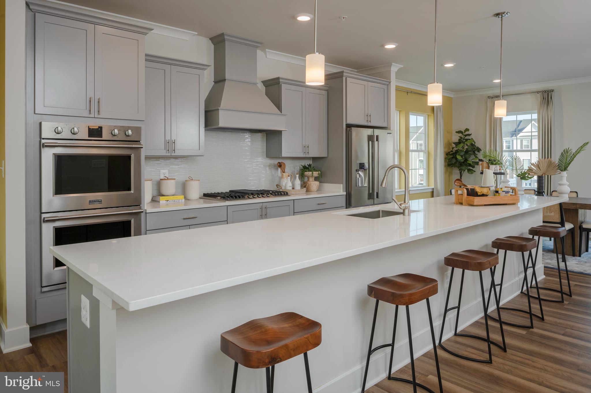 7708 Johnnycake Road Windsor Mill, MD 21244 - Photo 3 of 18 a kitchen with stainless steel appliances a dining table chairs microwave and stove top oven