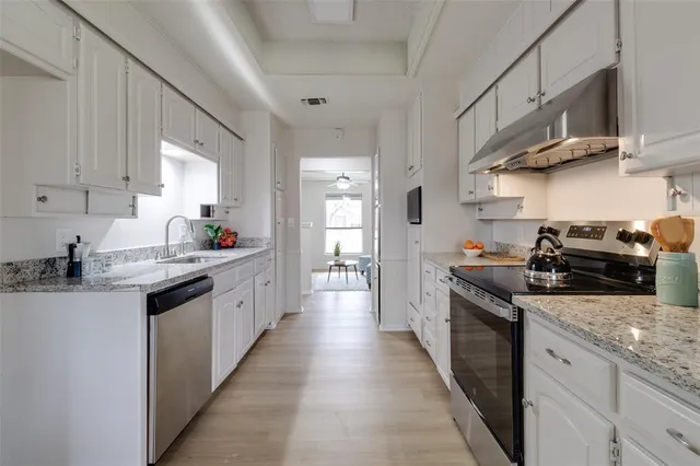 a kitchen with stainless steel appliances granite countertop a sink stove and cabinets
