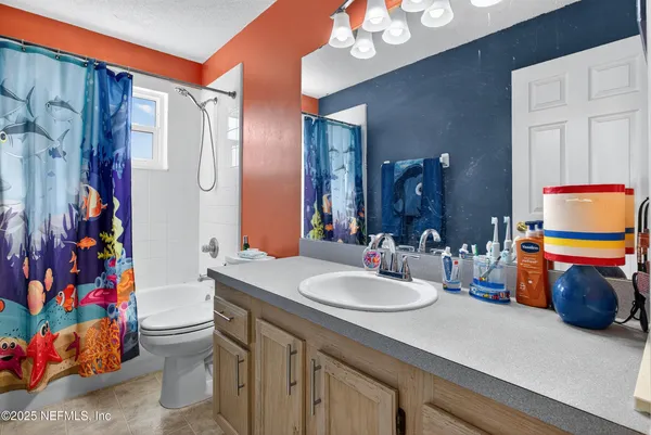 a bathroom with a sink vanity mirror and toilet