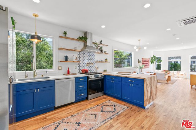 a kitchen with stainless steel appliances granite countertop sink stove and wooden floor