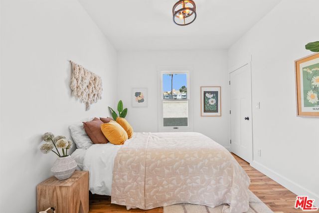 a bedroom with a bed and painting on the wall