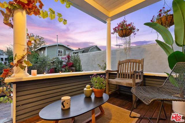 a view of a balcony with chairs potted plants