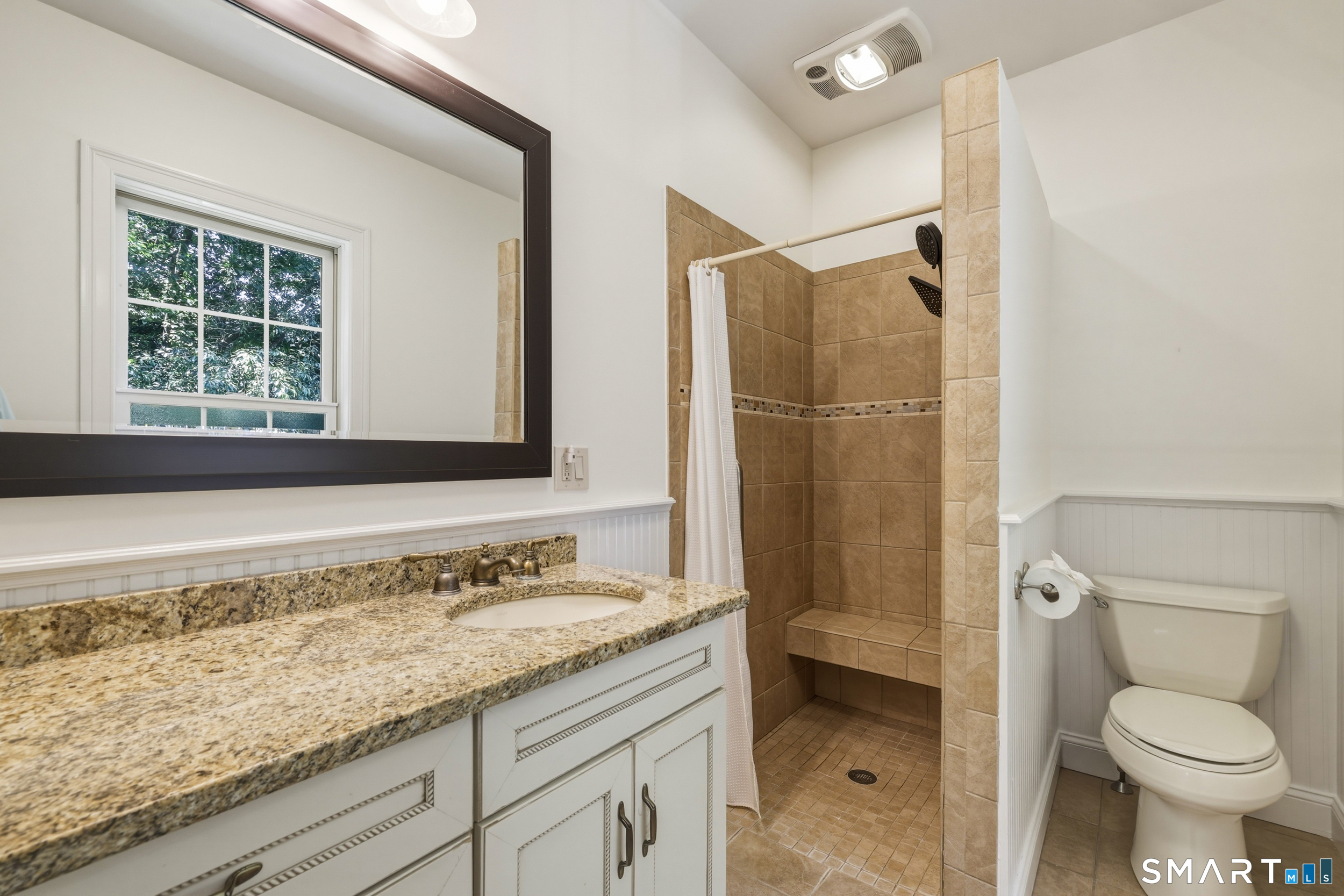 122 Lower Road Guilford, CT 06437 - Photo 19 of 40 The ensuite bath for Bedroom #2 features tile flooring, bead-board accent detail, and a shower with tile surround.